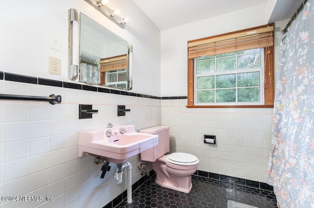 bathroom with tile patterned flooring, tile walls, toilet, and a shower with curtain