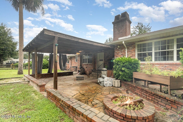 view of patio featuring ceiling fan and a fire pit