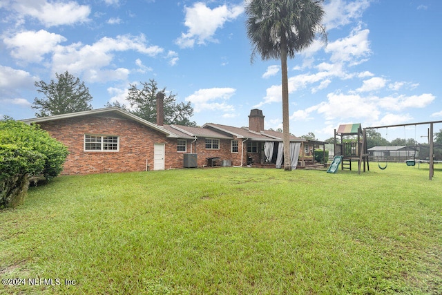 back of house with a yard, a playground, and cooling unit