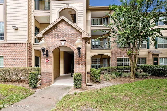 view of front facade featuring a balcony and a front lawn