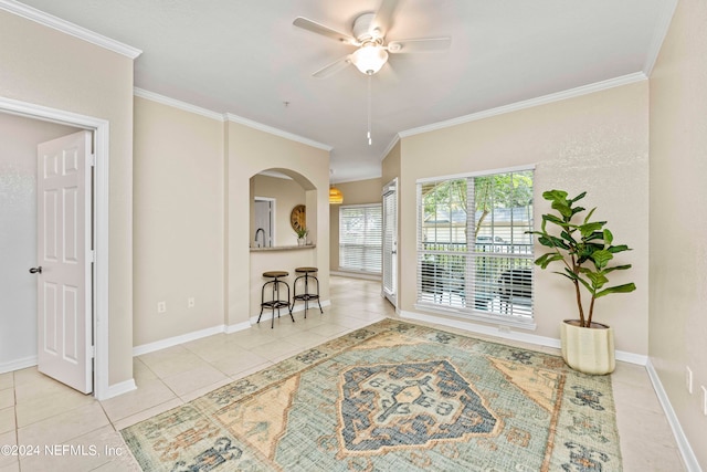 interior space featuring light tile patterned flooring, crown molding, and ceiling fan