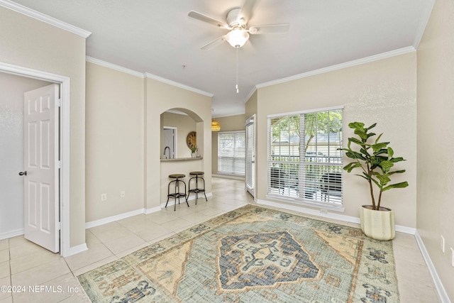 interior space featuring ceiling fan, baseboards, crown molding, and tile patterned flooring