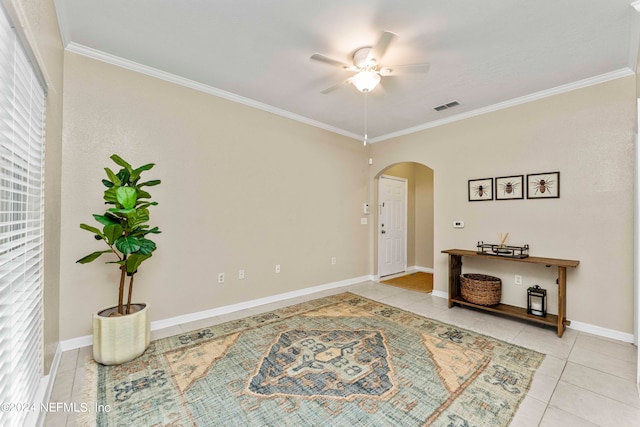 interior space featuring light tile patterned flooring, crown molding, and ceiling fan