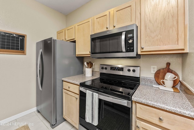 kitchen with light brown cabinetry, appliances with stainless steel finishes, baseboards, and light tile patterned floors