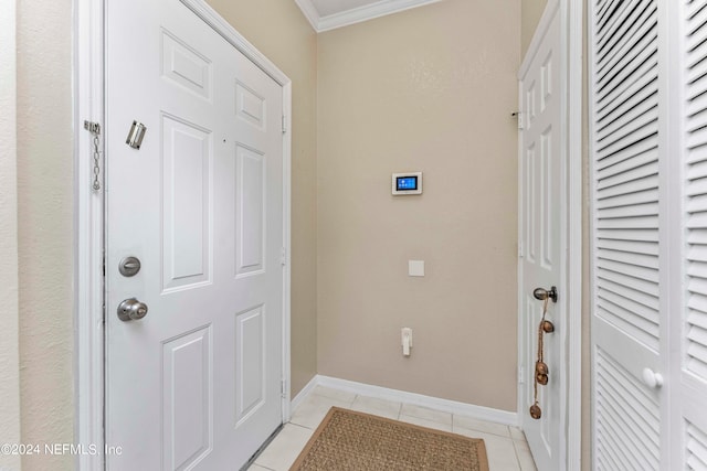 doorway with crown molding and light tile patterned floors