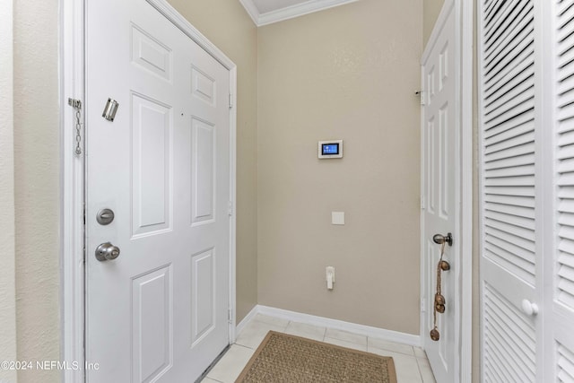 doorway featuring crown molding, baseboards, and light tile patterned floors