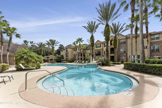 pool with a residential view and a patio