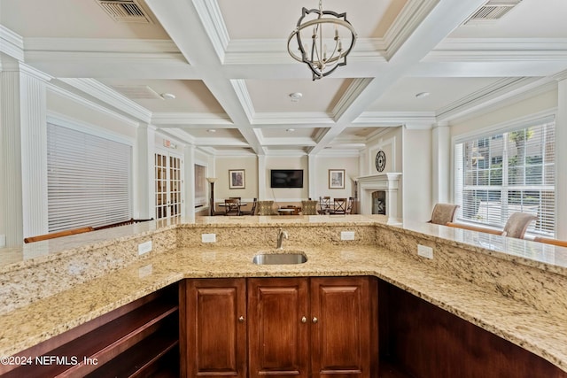 kitchen with hanging light fixtures, beam ceiling, sink, coffered ceiling, and crown molding