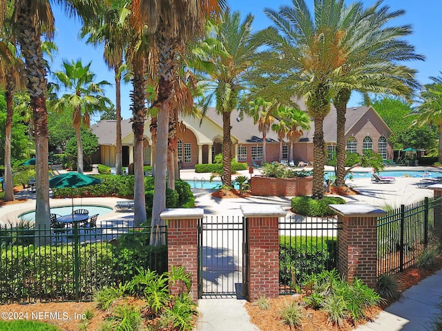 view of front of home with a community pool and a fenced front yard
