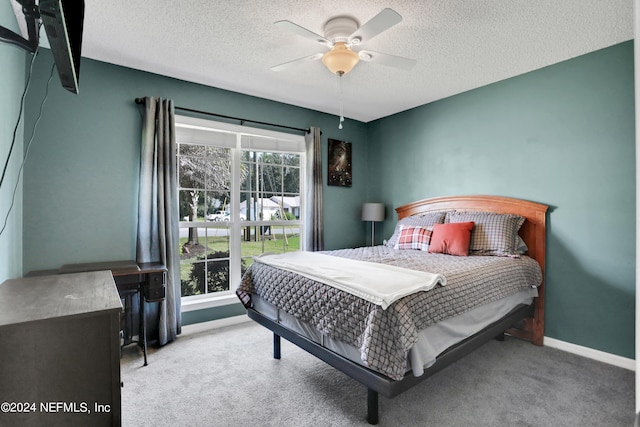 bedroom with ceiling fan, a textured ceiling, and light carpet