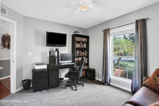 office area with a textured ceiling, carpet flooring, and ceiling fan