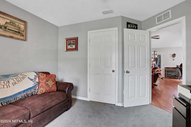 carpeted living room featuring a textured ceiling