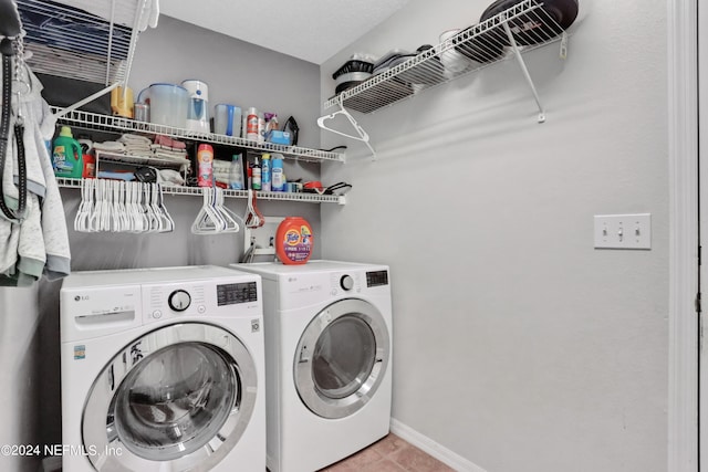 clothes washing area with washing machine and clothes dryer and tile patterned floors