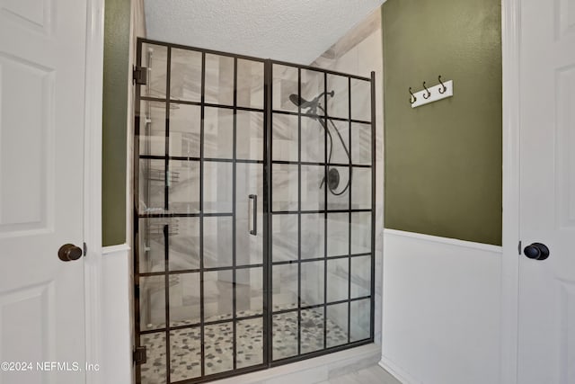 bathroom with walk in shower and a textured ceiling