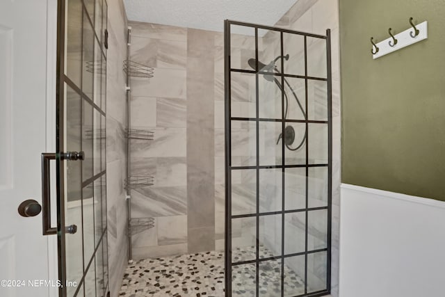 bathroom featuring walk in shower and a textured ceiling