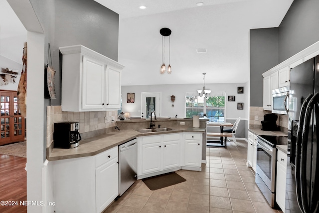 kitchen featuring hanging light fixtures, white cabinetry, kitchen peninsula, stainless steel appliances, and sink