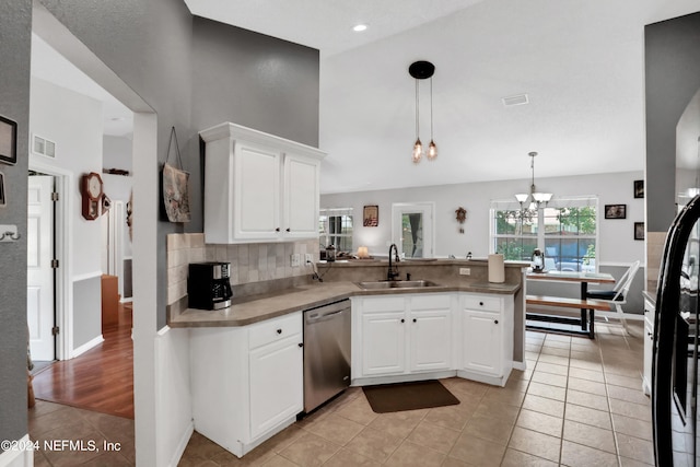 kitchen with white cabinets, light tile patterned floors, sink, kitchen peninsula, and stainless steel appliances