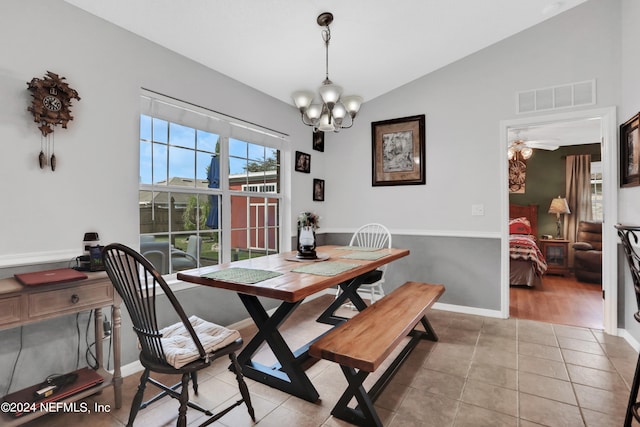 dining space featuring ceiling fan with notable chandelier, vaulted ceiling, and light tile patterned floors