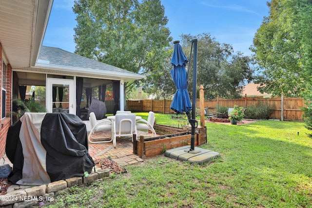 view of yard with a sunroom and a patio