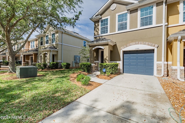 townhome / multi-family property with a front yard and a garage