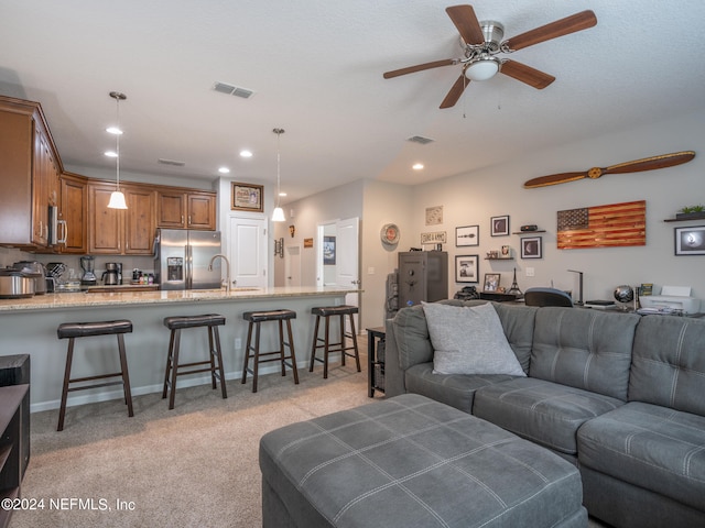 living room featuring light carpet, sink, and ceiling fan