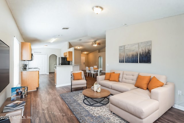 living room featuring vaulted ceiling, dark wood-type flooring, and ceiling fan