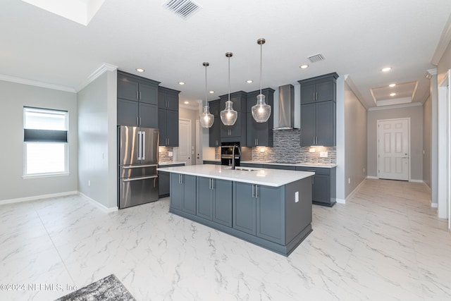 kitchen featuring tasteful backsplash, pendant lighting, an island with sink, high quality fridge, and wall chimney exhaust hood