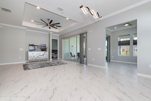 unfurnished living room with a tray ceiling, a textured ceiling, ceiling fan, and crown molding