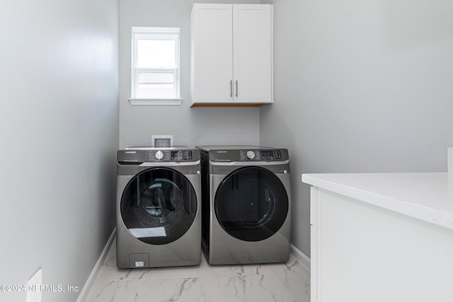 clothes washing area featuring cabinets and independent washer and dryer