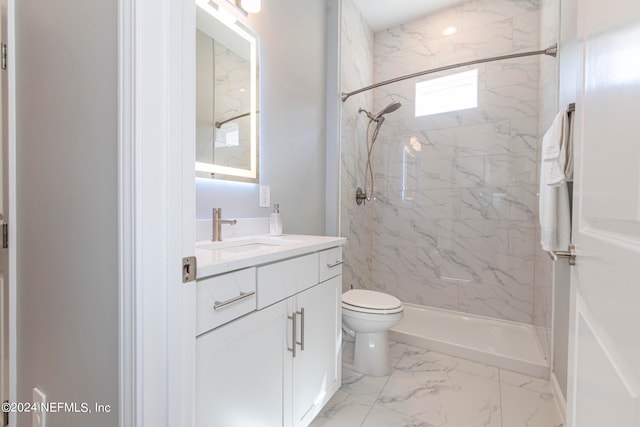 bathroom featuring toilet, vanity, and tiled shower