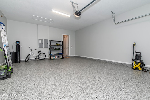 garage with a garage door opener and electric panel