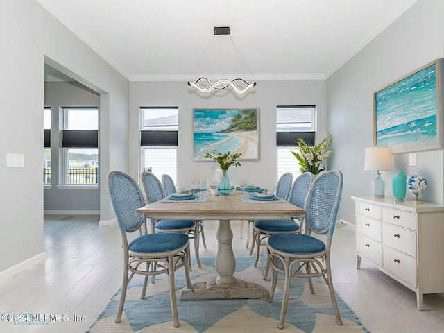 dining area with a wealth of natural light, crown molding, and light hardwood / wood-style floors