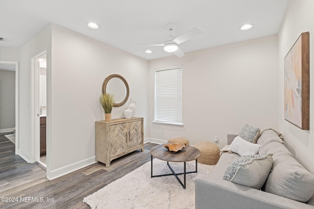 living room featuring ceiling fan and dark wood-type flooring