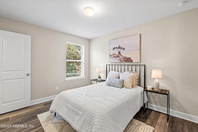 bedroom featuring dark wood-type flooring and a textured ceiling