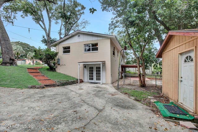 back of property with a yard and french doors