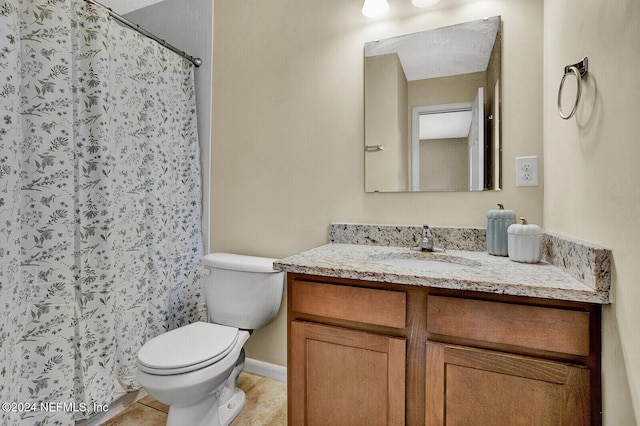 bathroom with a shower with curtain, vanity, toilet, and tile patterned floors