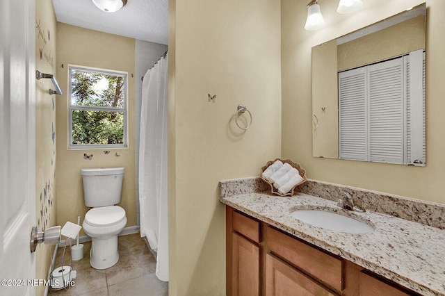 bathroom featuring tile patterned floors, vanity, and toilet