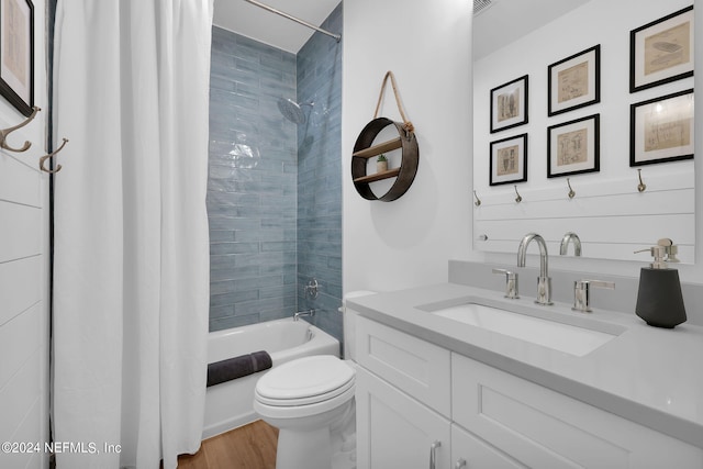 full bathroom with hardwood / wood-style floors, shower / bathtub combination with curtain, toilet, and vanity