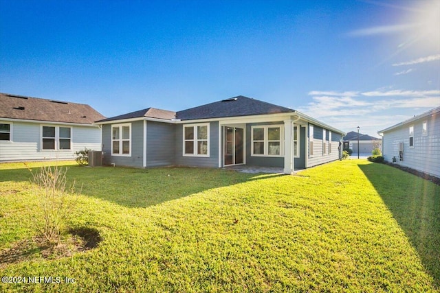 rear view of house featuring a yard and central AC unit