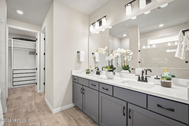 bathroom with vanity, hardwood / wood-style flooring, and tiled shower