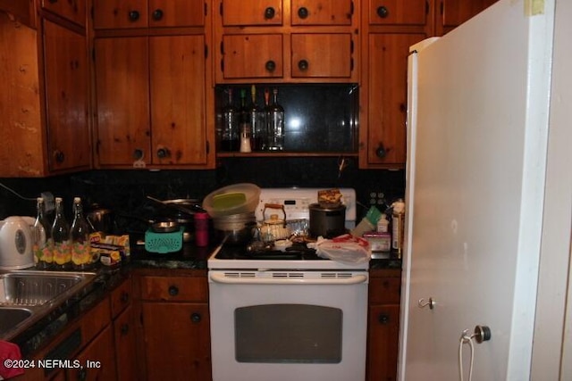 kitchen featuring white electric range oven, sink, and tasteful backsplash