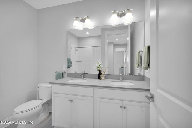 bathroom with curtained shower, vanity, and toilet