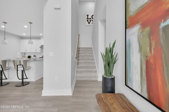 staircase with hardwood / wood-style flooring and sink