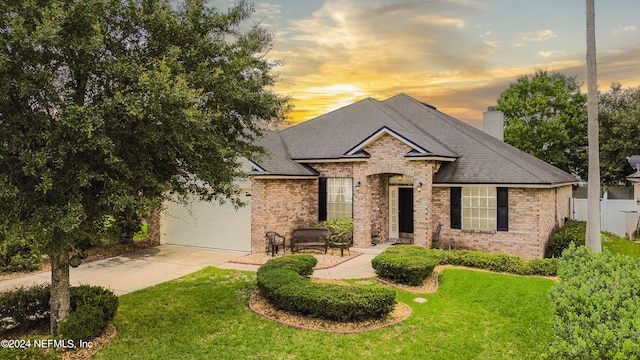 view of front of property with a garage and a yard