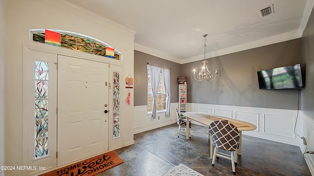 foyer with an inviting chandelier and crown molding