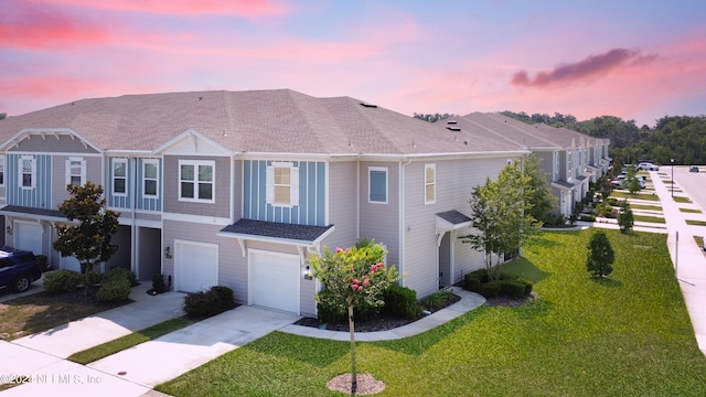 view of property with a lawn and a garage