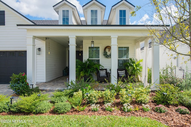 view of front of home featuring a porch and a garage