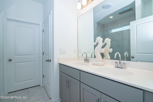 bathroom with vanity, tile patterned flooring, and tiled shower