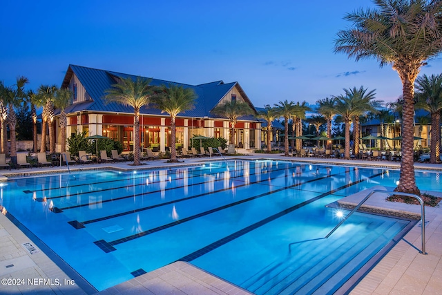 pool at dusk with a patio area