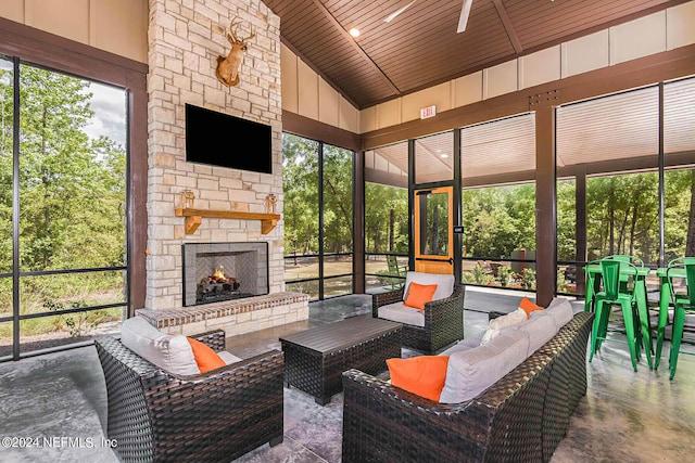 sunroom with lofted ceiling, wood ceiling, and an outdoor stone fireplace